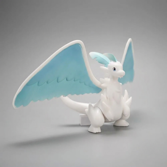 White-and-blue Quivern figurine from Palworld standing with its large wings spread against a soft gray background.