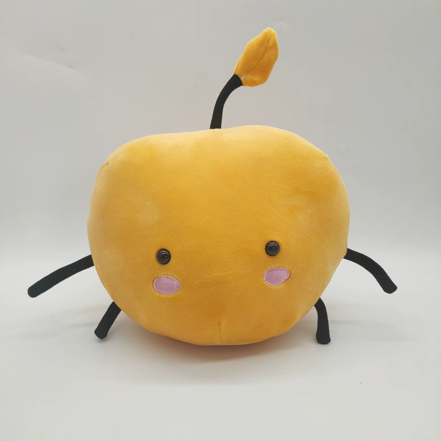 Yellow Junimo plushie from Stardew Valley displayed on a table