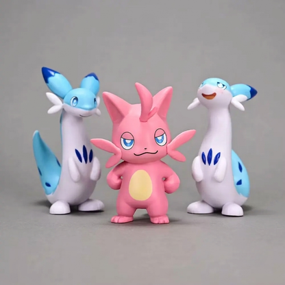 Three Palworld figurines on a gray background: a pink Cattiva stands in the center, flanked by two tall blue-and-white Chillets.