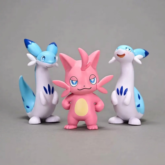 Three Palworld figurines on a gray background: a pink Cattiva stands in the center, flanked by two tall blue-and-white Chillets.