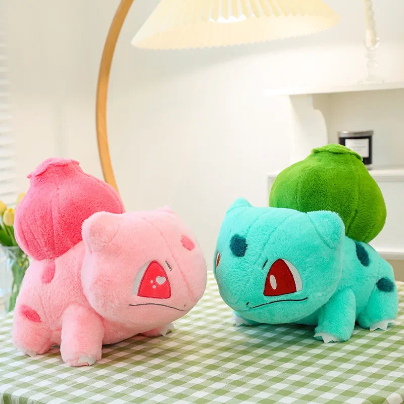 Blue and pink Bulbasaur plushies from the Bulbasaur Duo Set displayed on a decorative surface