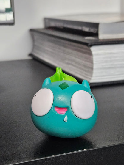 Funny Bulbasaur figurine with wide, derpy eyes, a playful smile, and its signature green bulb, bringing a humorous twist to the classic Pokémon design