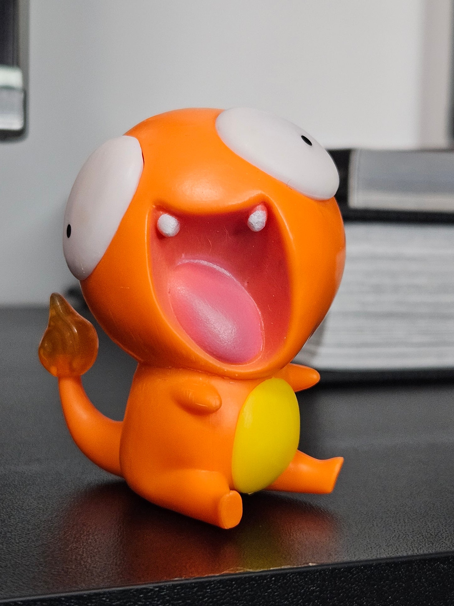 Funny Charmander figurine with a wide-open mouth, derpy eyes, and an exaggerated playful design, perfect for adding humor to any Pokémon collection