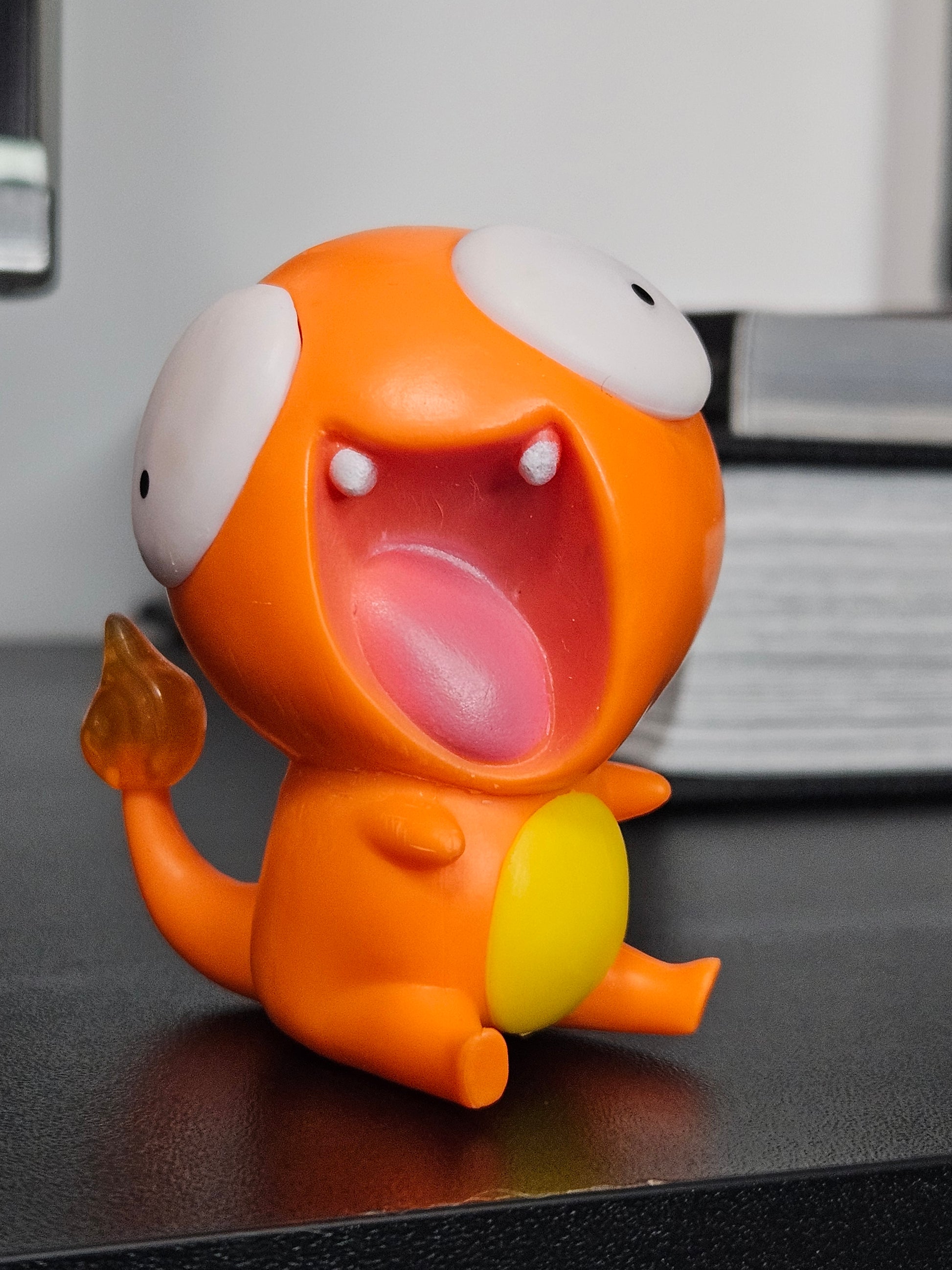 Funny Charmander figurine with a wide-open mouth, derpy eyes, and an exaggerated playful design, perfect for adding humor to any Pokémon collection