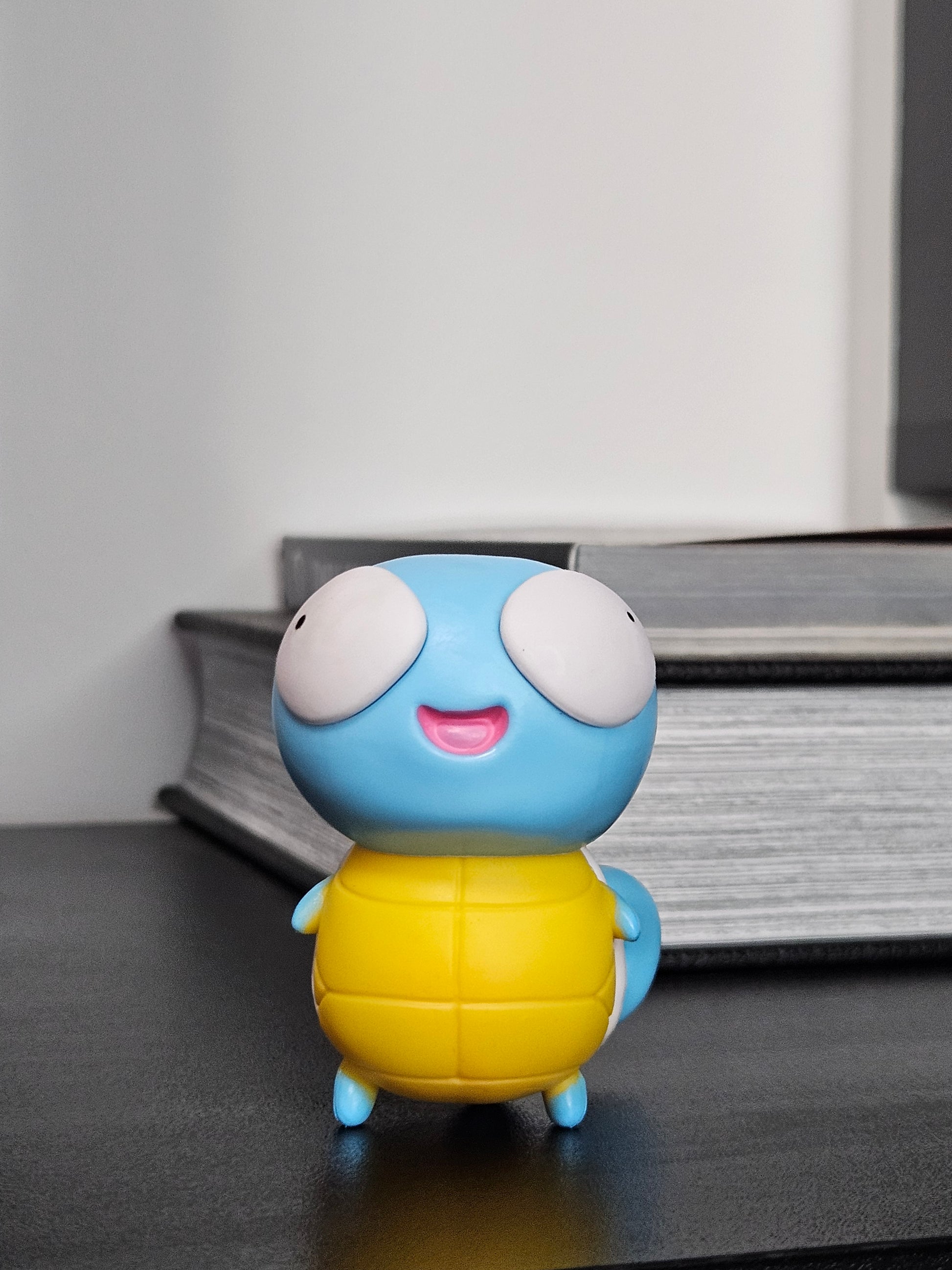 Funny Squirtle figurine with wide, derpy eyes and a cheerful smile, featuring its classic blue body and yellow shell, perfect for adding humor to any Pokémon collection or display